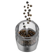 Elektromühle aus Edelstahl mit transparentem Behälter, gefüllt mit Pfefferkörnern, aus der Vogelperspektive.