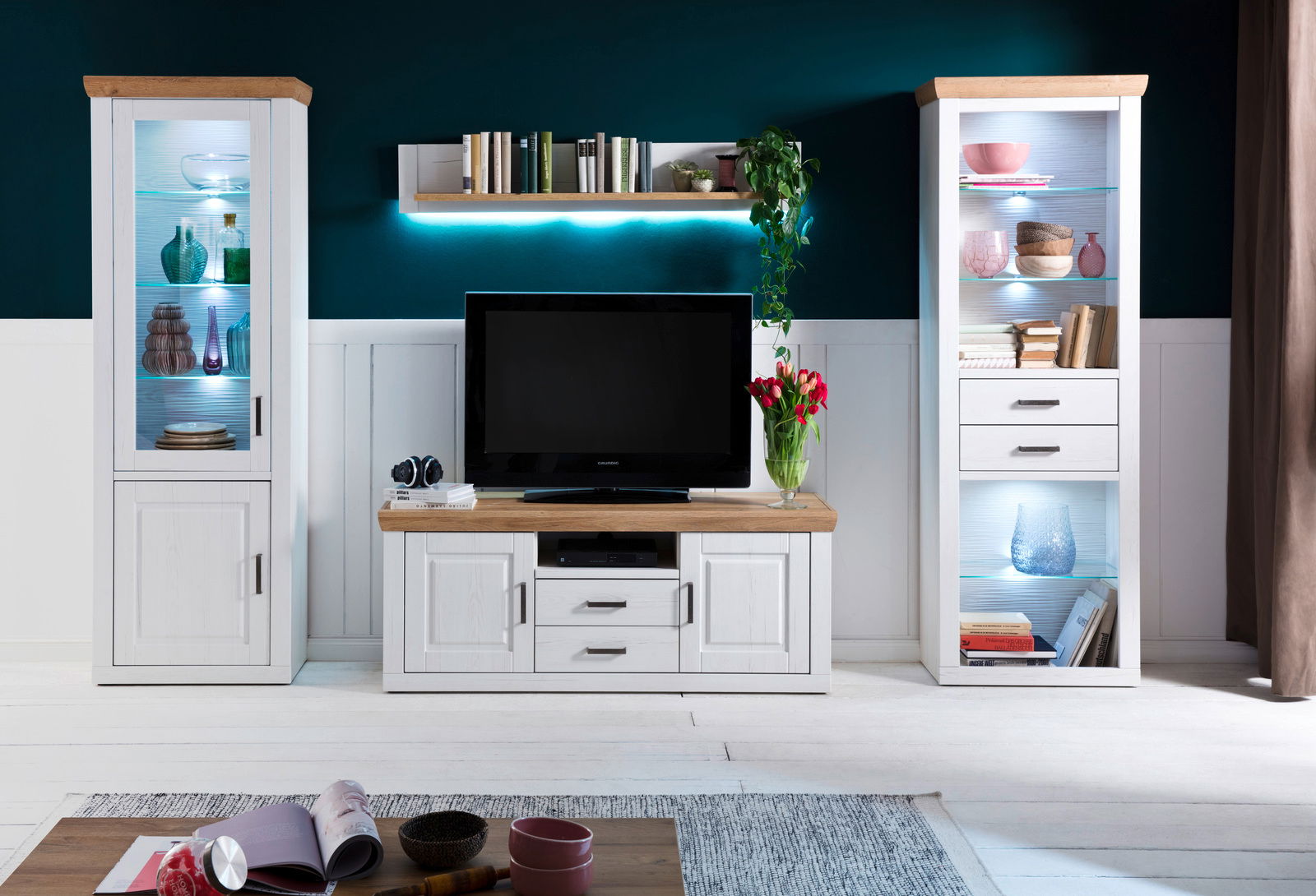 Moderne Wandkombination mit zwei weißen Vitrinen, einem TV-Schrank und einem Regalbrett, frontal betrachtet.
