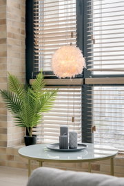 Hängeleuchte mit federartigem Design, beleuchtet in einem modernen Wohnzimmer, seitliche Perspektive