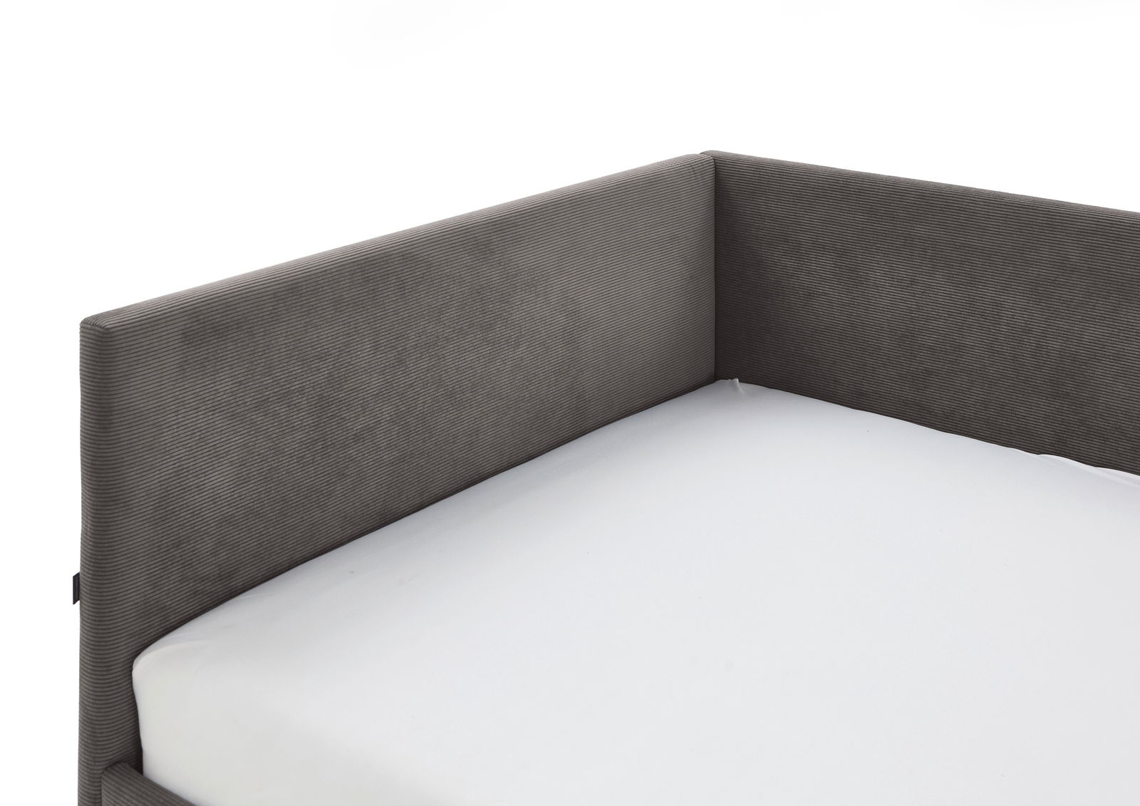 Ecke einer grauen Polsterliege mit weißer Matratze, seitliche Perspektive