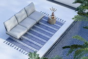 Dreier-Sitzer Loungeelement auf einem blauen Teppich neben einem Pool, aus der Vogelperspektive betrachtet.