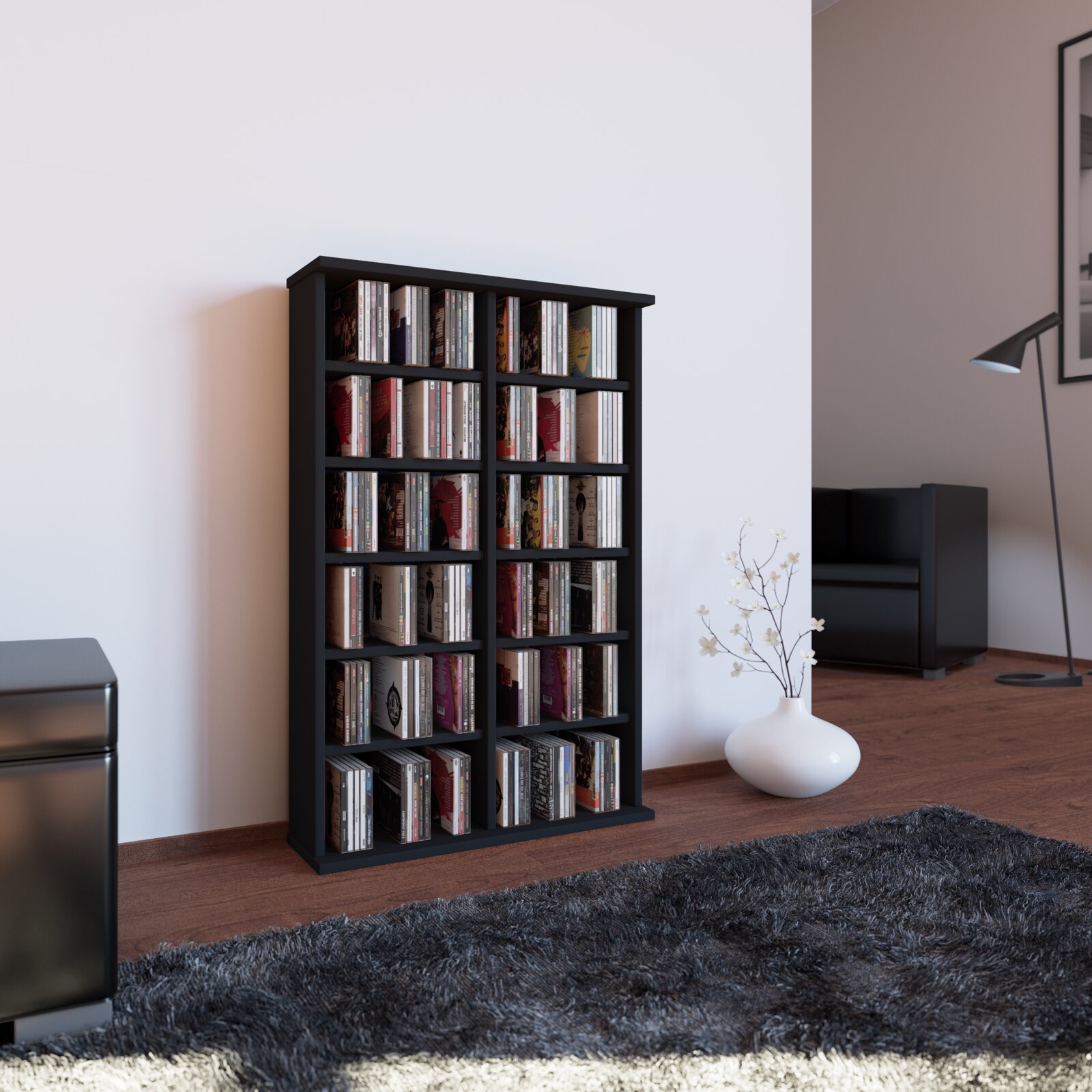 Schwarzes CD/DVD-Regal mit mehreren Fächern, gefüllt mit CDs, in modernem Wohnzimmer auf Holzboden Perspektive: leicht seitliche Frontansicht auf Augenhöhe.