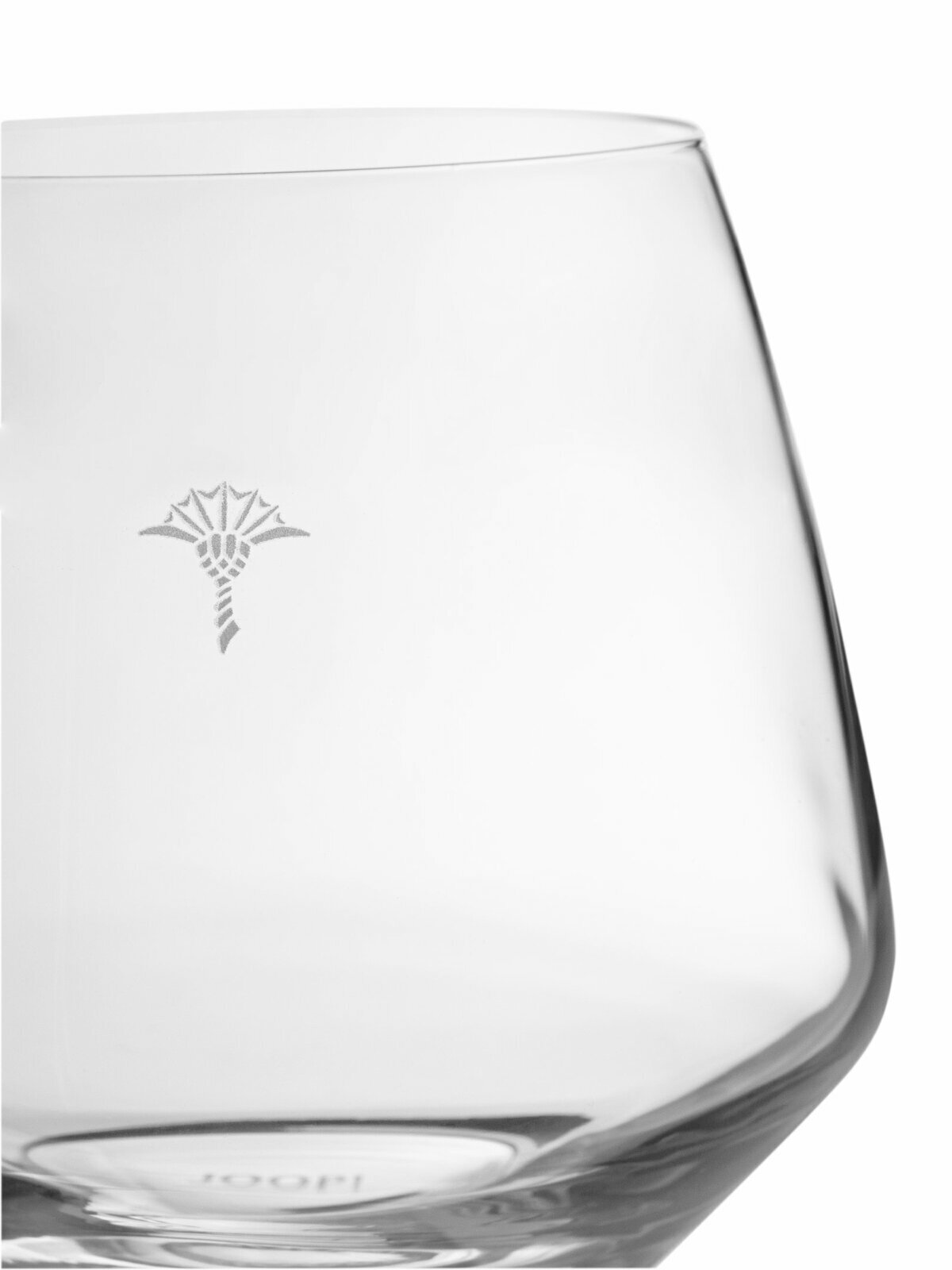 Nahaufnahme eines klaren Wasserglases mit dezentem Muster, seitliche Perspektive