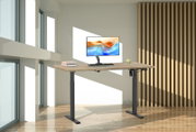 Elektrisch höhenverstellbarer Schreibtisch mit Holzplatte und schwarzen Metallbeinen, mit Monitor und Tastatur in modernem, hellem Büro – frontale Perspektive auf das Produkt.