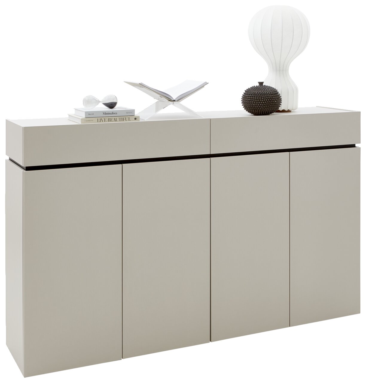 Modernes Sideboard in hellem Beige mit vier Türen, dekoriert mit Büchern, einer Lampe und einer Skulptur, seitliche Perspektive