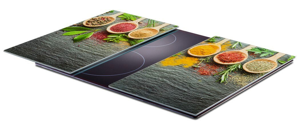 Herdabdeck- und Schneideplatten-Set mit bunten Gewürzen und Kräutern auf einer Schieferoptik, seitliche Perspektive.