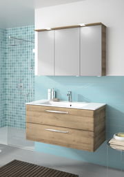 Moderner Badblock mit Holzoptik und weißen Schranktüren, frontal betrachtet. Integrierte Waschbeckenarmatur und stilvolle Beleuchtung.