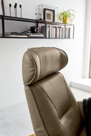 Nahaufnahme eines beigen Relaxsessels mit Kopfstütze, seitliche Perspektive.