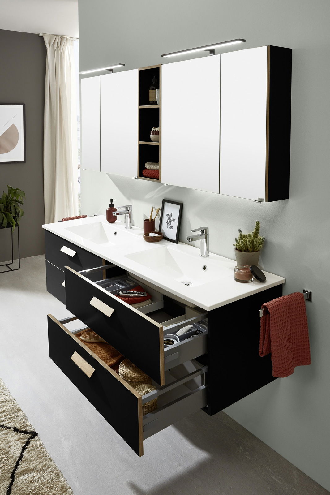 Moderne Badkombination mit Doppelwaschbecken, schwarzen Schubladen und weißen Spiegelschränken, aus der linken Perspektive betrachtet.
