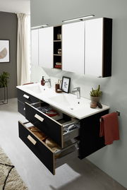 Moderne Badkombination mit Doppelwaschbecken, schwarzen Schubladen und weißen Spiegelschränken, aus der linken Perspektive betrachtet.