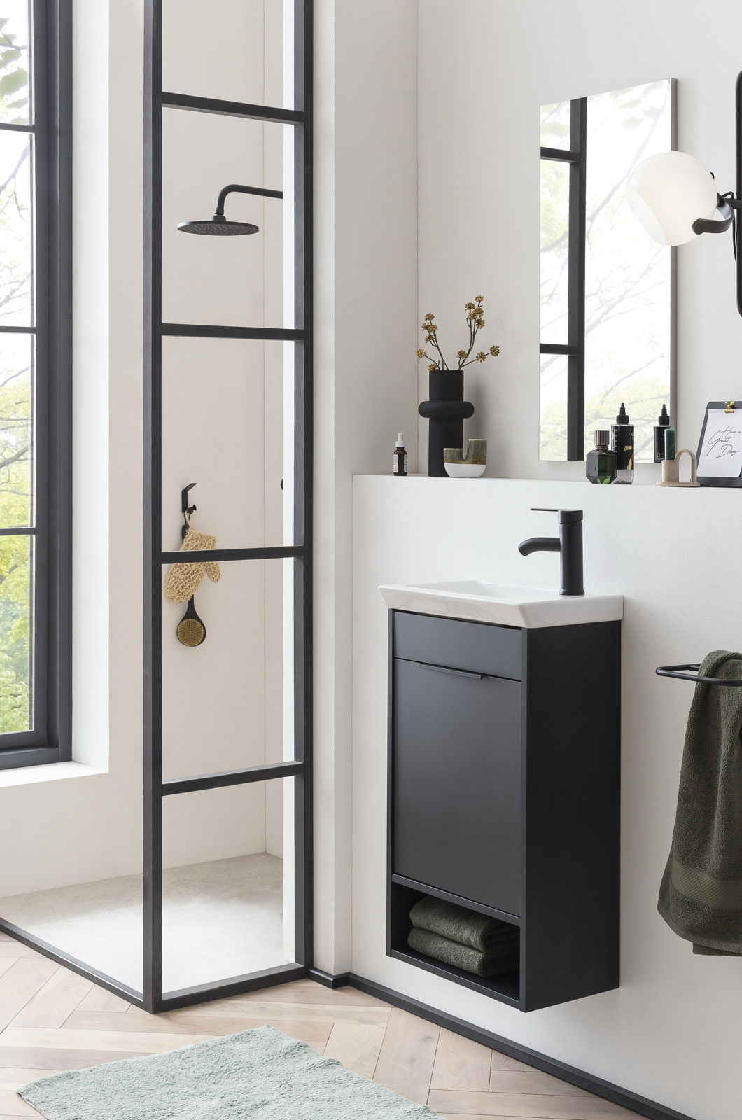 Stylife Gästebad 3-tlg. TOTO Modernes Gästebad mit schwarzem Waschbeckenunterschrank, Spiegel und Dusche in seitlicher Perspektive.