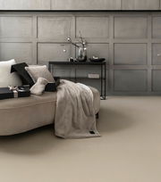 Elegantes Geschenkset mit weicher Decke und Kissen auf einem Sofa, seitliche Perspektive