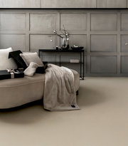 Elegantes Geschenkset mit weicher Decke und Kissen auf einem Sofa, seitliche Perspektive