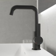 Moderne schwarze Waschtischarmatur in seitlicher Perspektive auf einem weißen Waschbecken montiert.
