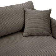 Close-up van een grijze ronde hoekbank met geribbelde bekleding en bijpassend kussen.