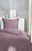 Westminister Bettwäsche STONE-WASHED Lila Bettwäsche-Set auf einem Bett, frontal fotografiert, mit dekorativen Elementen im Hintergrund.