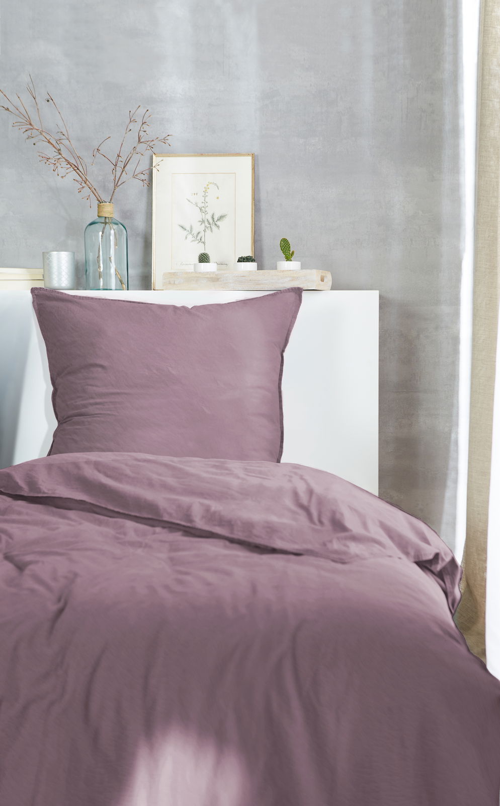 Westminister Bettwäsche STONE-WASHED Lila Bettwäsche-Set auf einem Bett, frontal fotografiert, mit dekorativen Elementen im Hintergrund.
