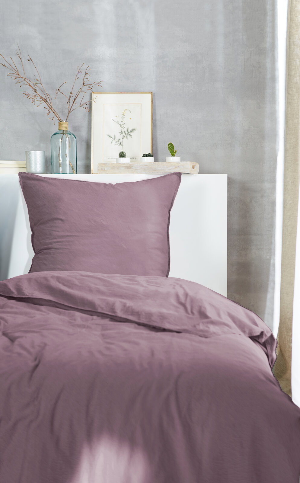 Westminister Bettwäsche STONE-WASHED Lila Bettwäsche-Set auf einem Bett, frontal fotografiert, mit dekorativen Elementen im Hintergrund.