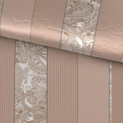 Nahaufnahme aus schräger Draufsicht auf eine gerollte Tapete in Beige mit Streifen und Paisley-Ornamentmuster