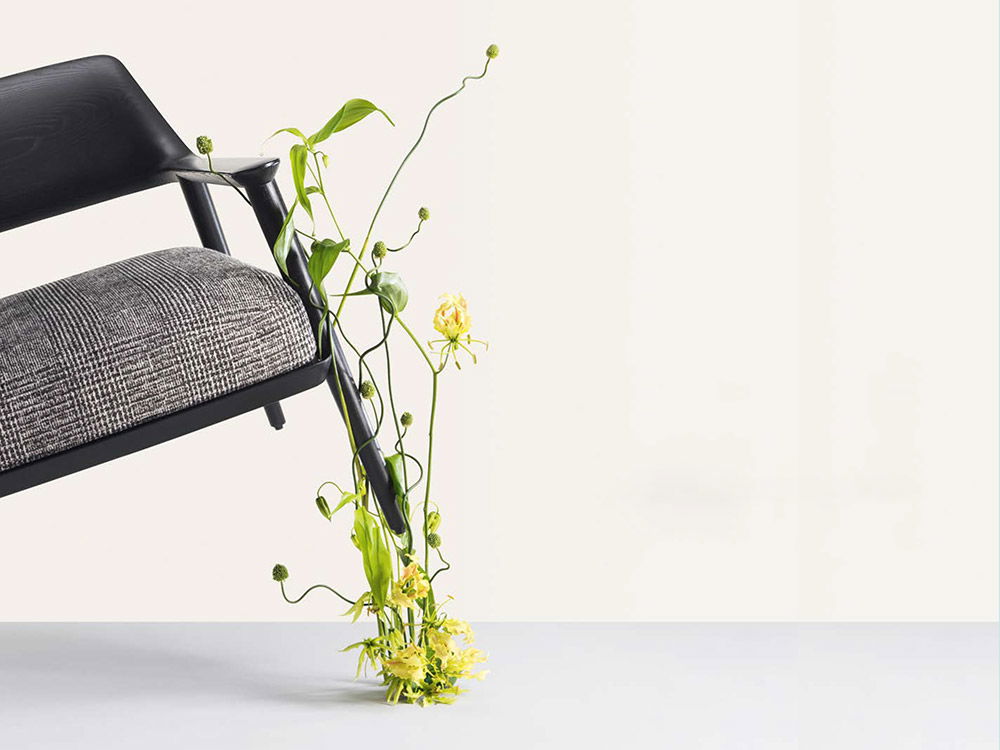 Das Magazin 2023 zeigt einen schwarzen Stuhl, angelehnt an einer Wand. Eine Blumenranke wächst am Stuhlbein empor.