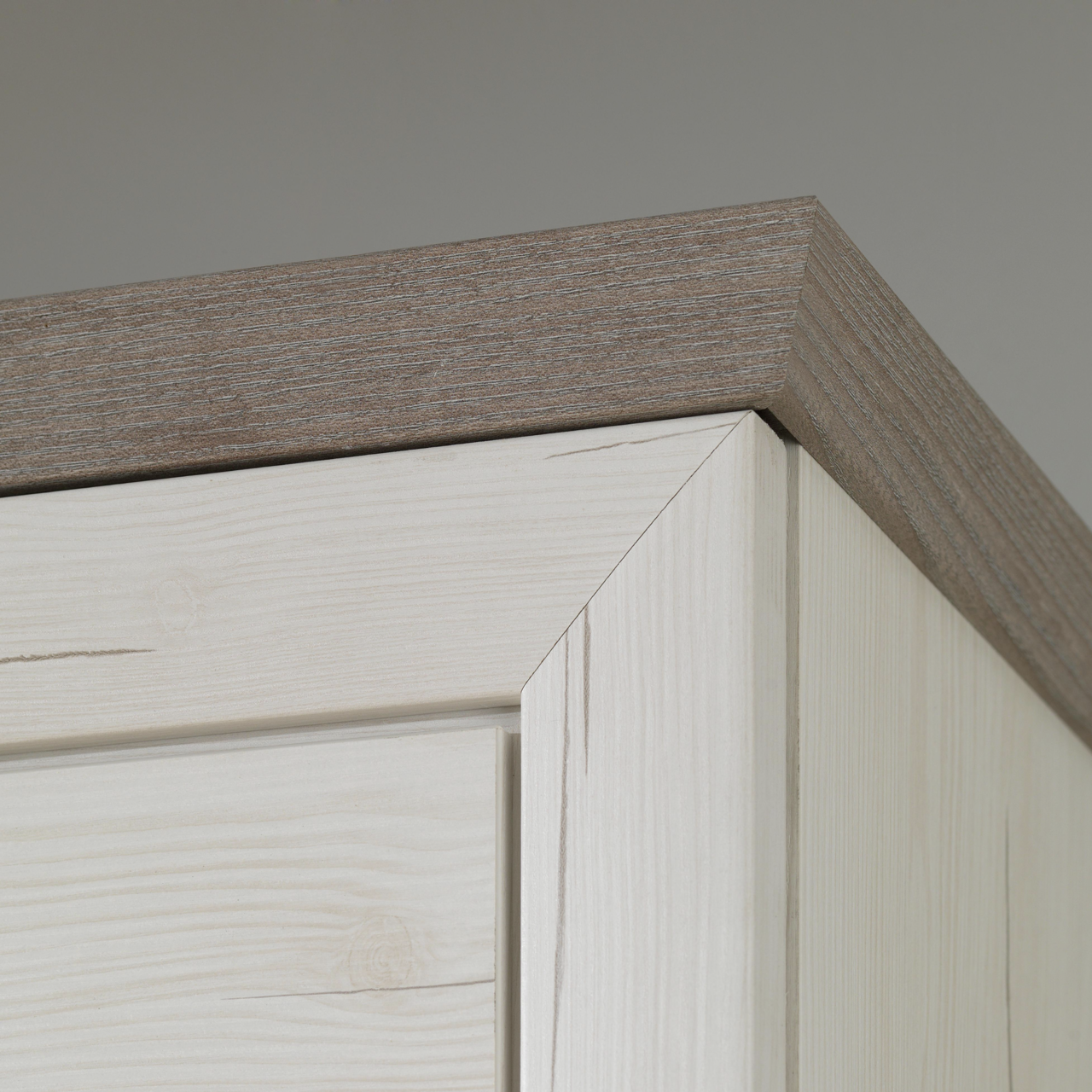 Nahaufnahme der oberen Ecke eines Garderobenschranks aus der Serie Camron/Benton mit Holzmaserung, Perspektive von unten.