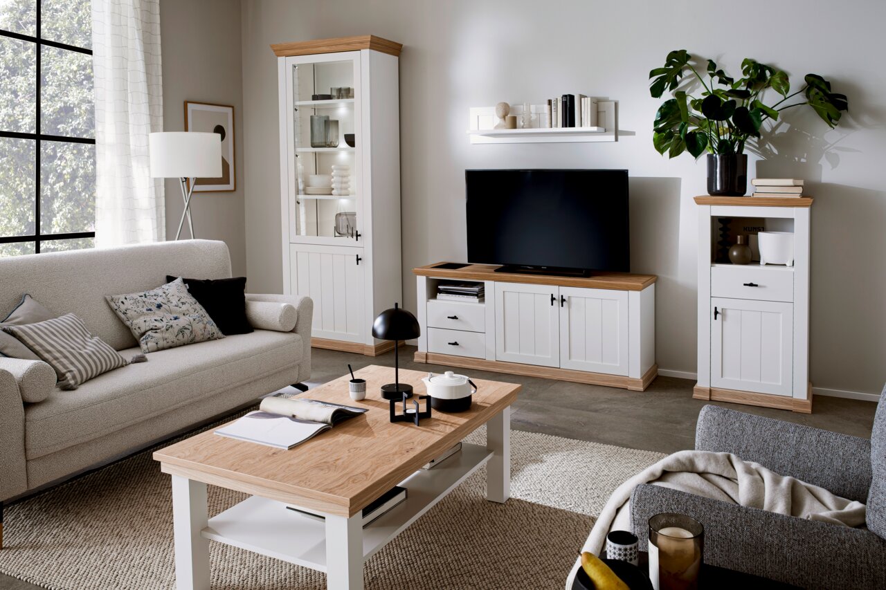 Moderner Couchtisch aus Holz mit weißem Gestell in einem stilvoll eingerichteten Wohnzimmer, seitliche Perspektive.