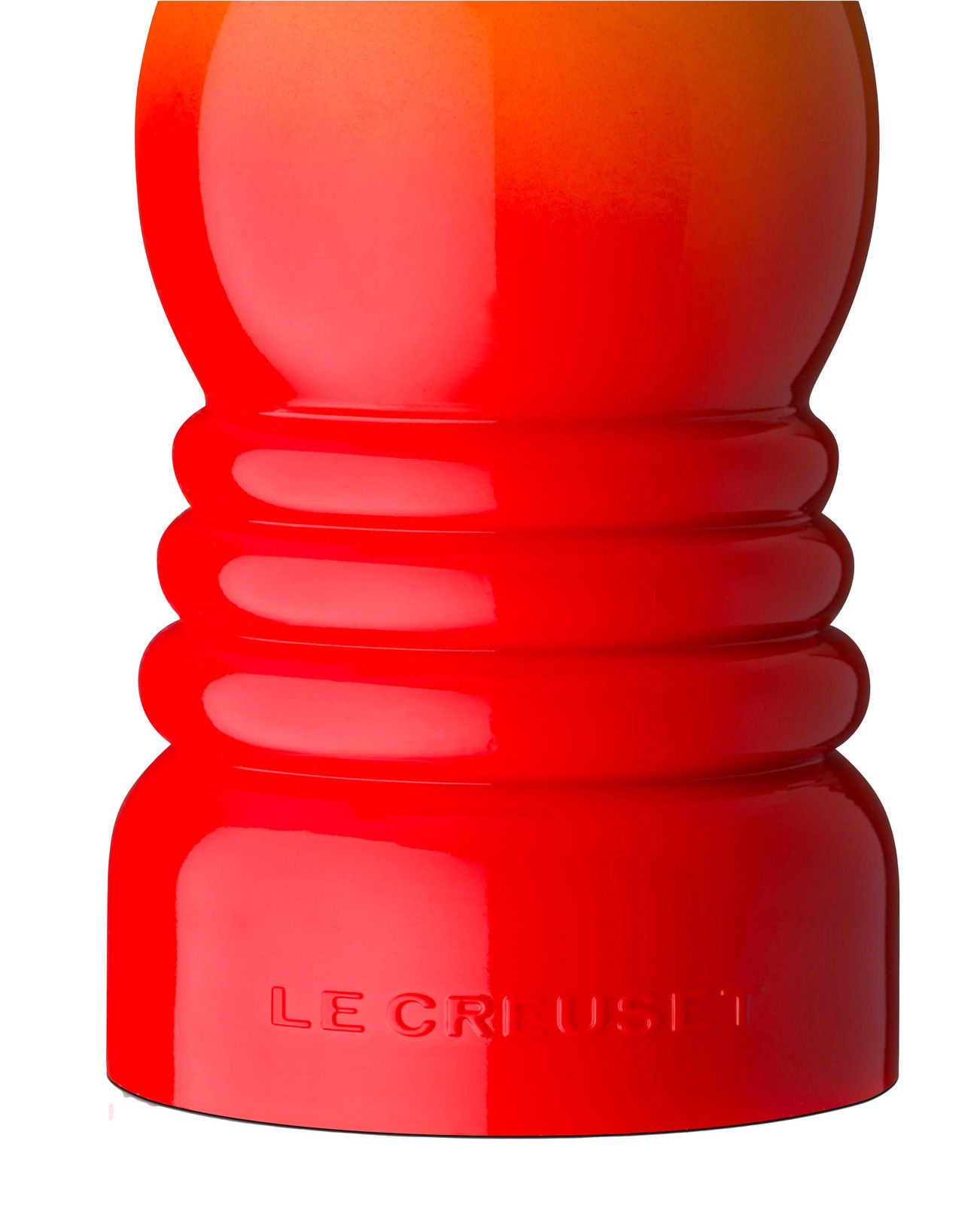 Nahaufnahme einer ofenroten Pfeffermühle von Le Creuset, seitliche Perspektive.