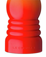 Nahaufnahme einer ofenroten Pfeffermühle von Le Creuset, seitliche Perspektive.