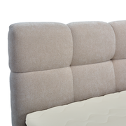 Nahaufnahme eines gepolsterten Boxbett-Kopfteil in Beige, seitliche Perspektive