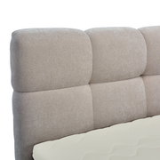 Nahaufnahme eines gepolsterten Boxbett-Kopfteil in Beige, seitliche Perspektive