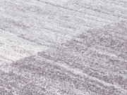 Nahaufnahme eines Frisé-Teppichs in Grautönen mit weicher, strukturierter Oberfläche, von schräg oben betrachtet.