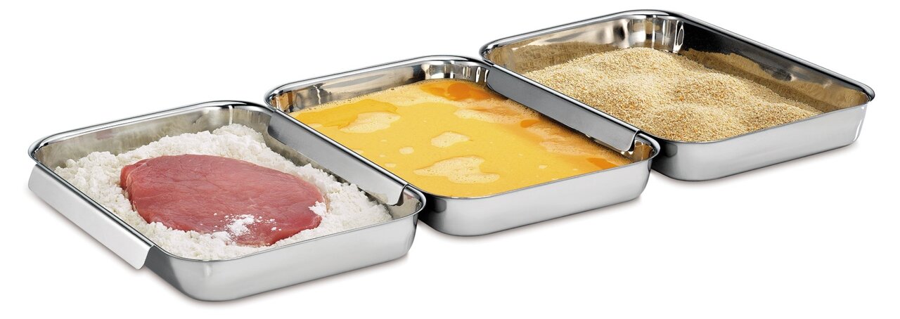 Drei Edelstahlbehälter in einer Reihe, gefüllt mit Mehl und Fleisch, Ei und Paniermehl, aus einer leicht erhöhten Perspektive.