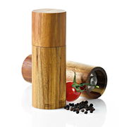 Pfeffer- oder Salzmühle aus Akazienholz, stehend und liegend, mit Pfefferkörnern und einer Tomate im Vordergrund, seitliche Perspektive
