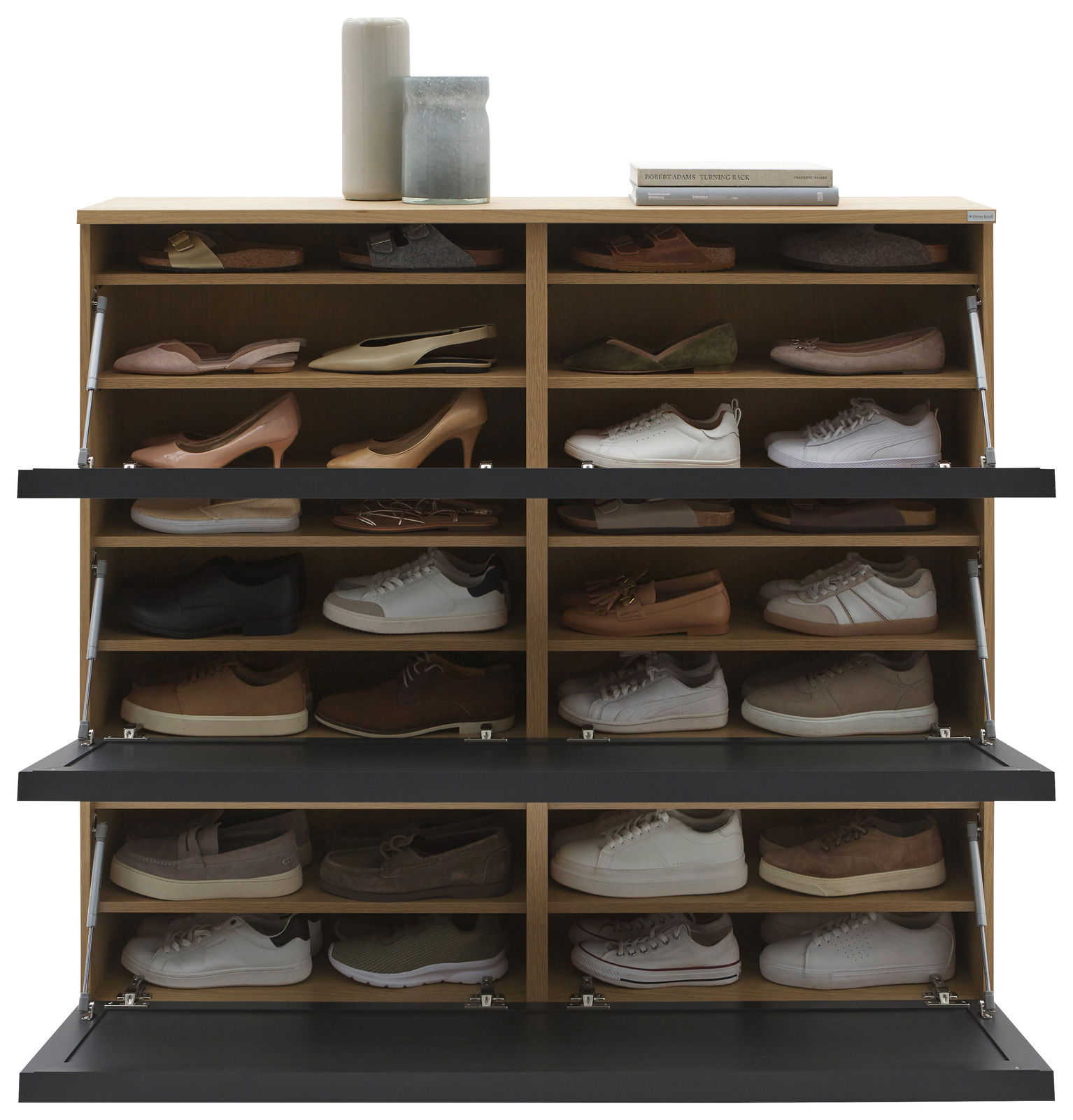 Vorderansicht eines XL-Schuhschranks mit mehreren Fächern, gefüllt mit verschiedenen Schuhen; oben dekoriert mit Vasen und Büchern.