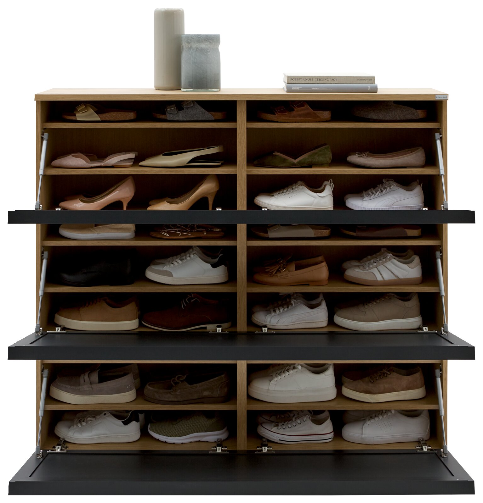 Vooraanzicht van een XL-schoenenkast met meerdere vakken, gevuld met verschillende schoenen; bovenaan versierd met vazen en boeken.