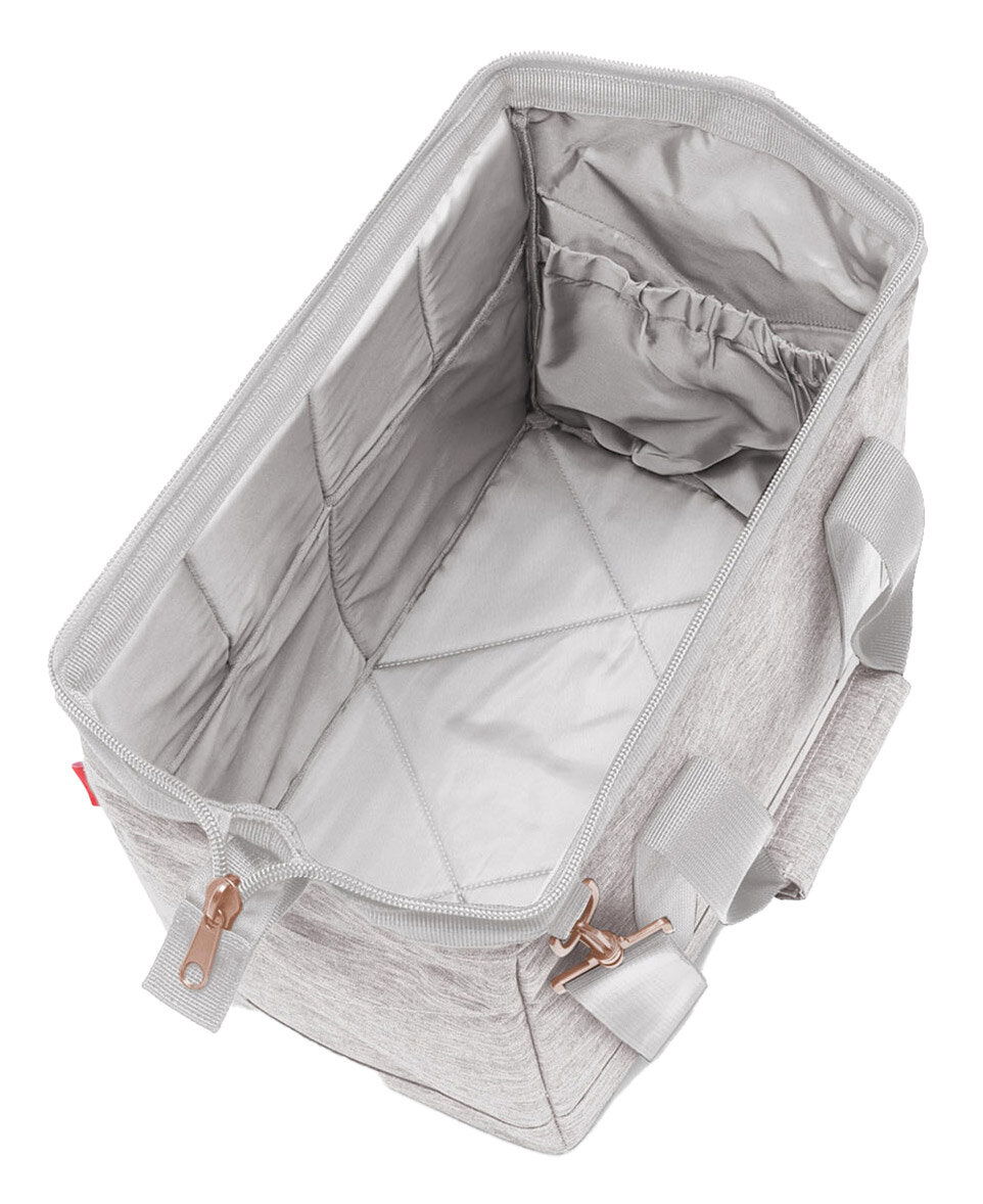 Innenansicht einer grauen Tasche mit Reißverschluss und Tragegriffen, von oben fotografiert.