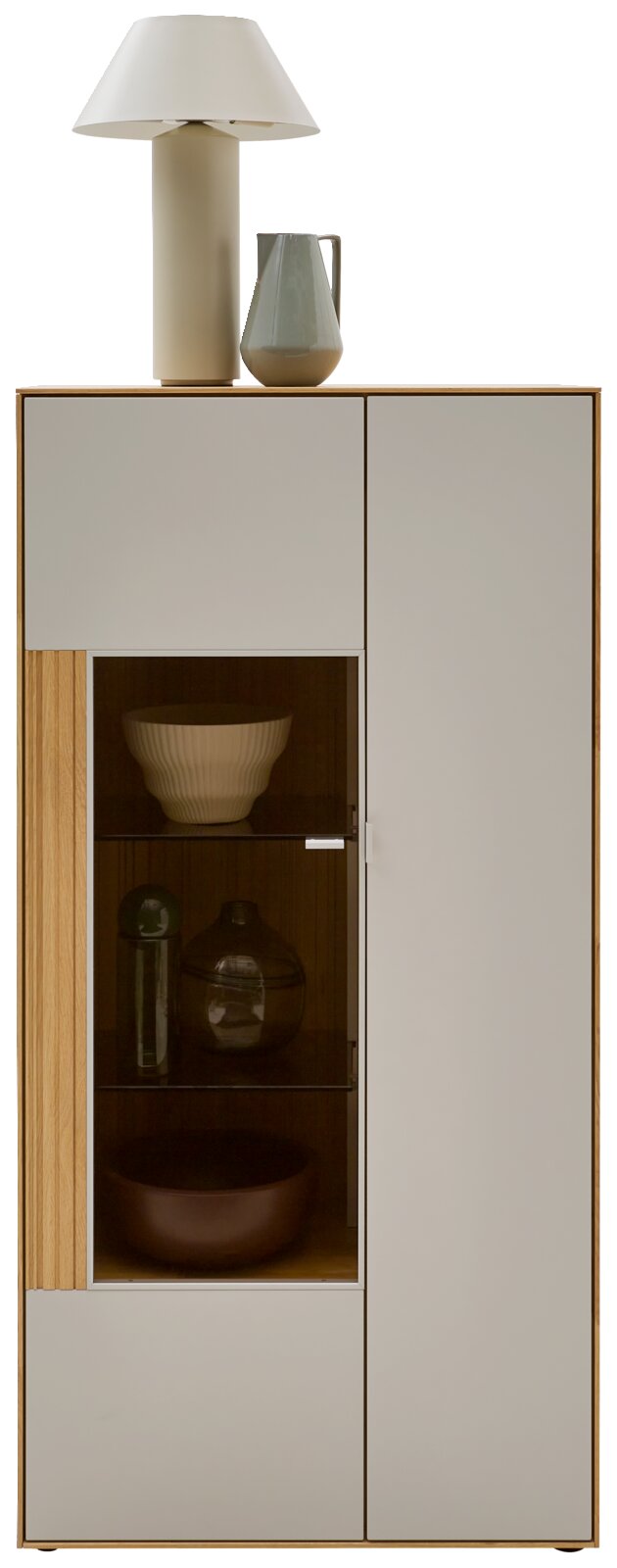 Modernes Sideboard/Highboard in Holzoptik mit hellgrauen Fronten und verglaster Vitrinentür, dekoriert mit Lampe und Krug, Frontalansicht