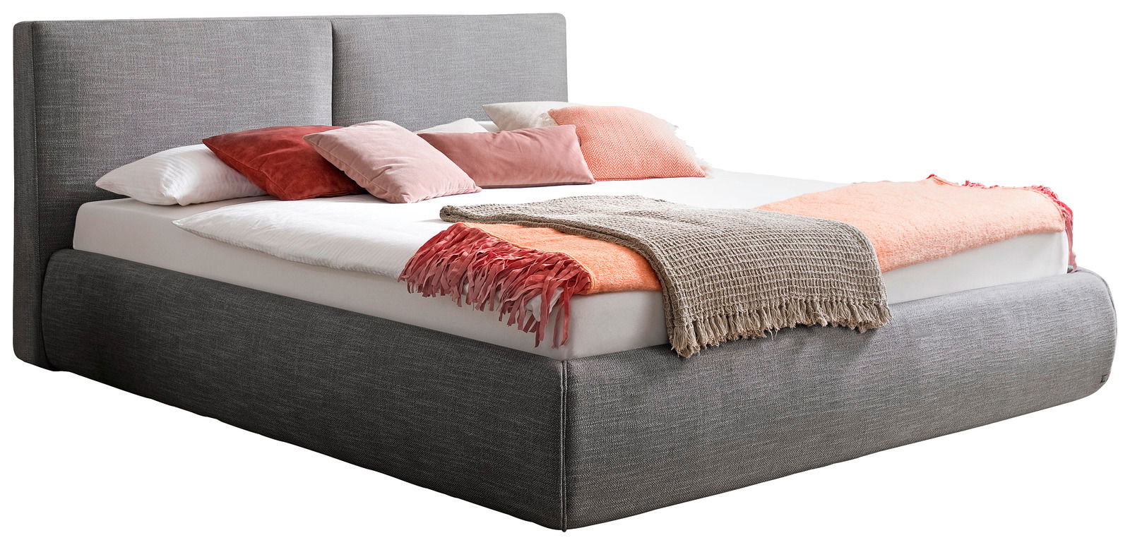 Graues Polsterbett in seitlicher Perspektive mit Kopfteil, dekoriert mit Kissen und Decken in Rosa- und Beigetönen.
