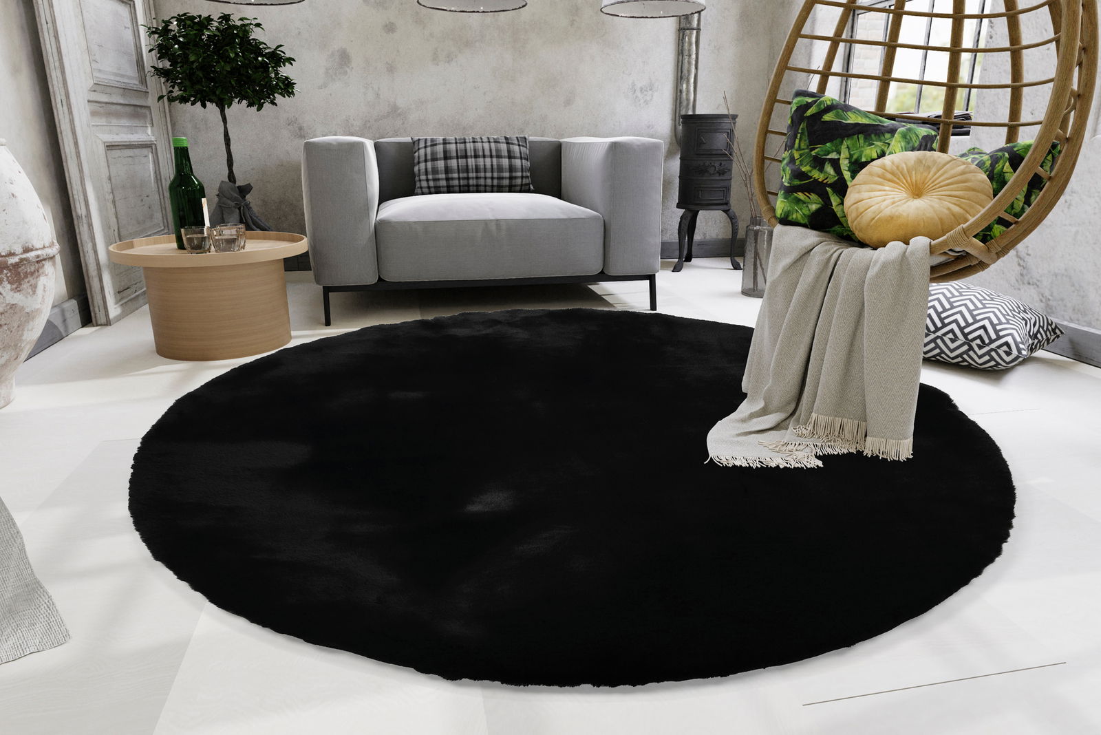 Runder schwarzer Fellteppich in einem modernen Wohnzimmer, Perspektive von oben.