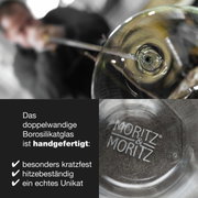 Close-up van een handgemaakt, dubbelwandig borosilicaatglas met het opschrift 'Moritz & Moritz'. Aanzicht van bovenaf op het glas.