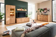 Moderne Wohnzimmermöbelkombination aus Holz mit Sideboard, TV-Schrank und Vitrine, aus der Perspektive eines gemütlichen Wohnzimmers mit Sofa im Vordergrund.
