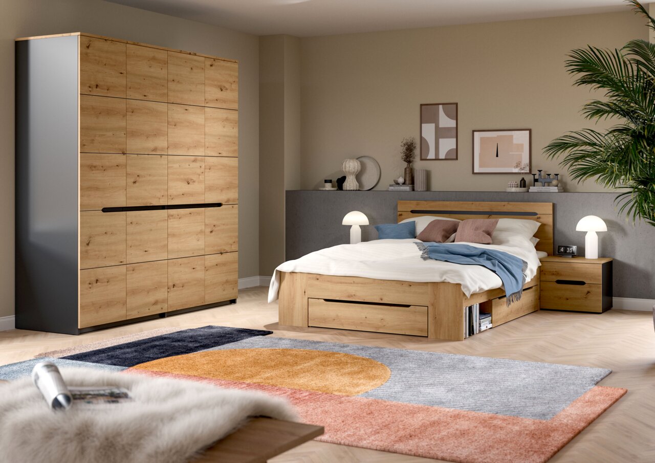 Modernes Schlafzimmer mit Holzbett inklusive Bettkasten und passendem Kleiderschrank in Eiche-Optik, Nachttisch und Lampen, fotografiert aus schräger Frontperspektive.