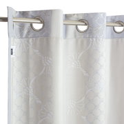 Ösenvorhang mit floralem Muster in Nahaufnahme, aufgehängt an einer Metallstange