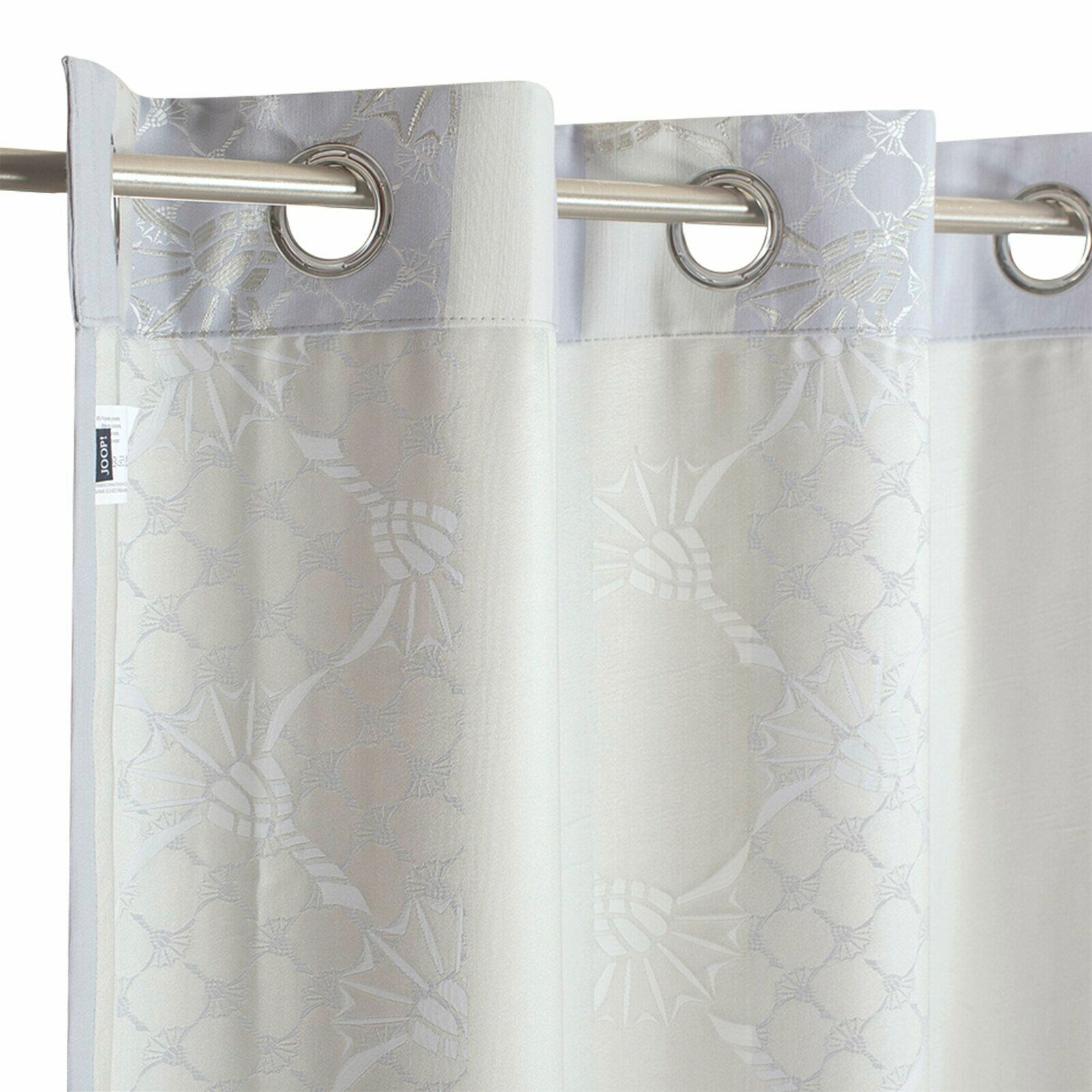 Ösenvorhang mit floralem Muster in Nahaufnahme, aufgehängt an einer Metallstange