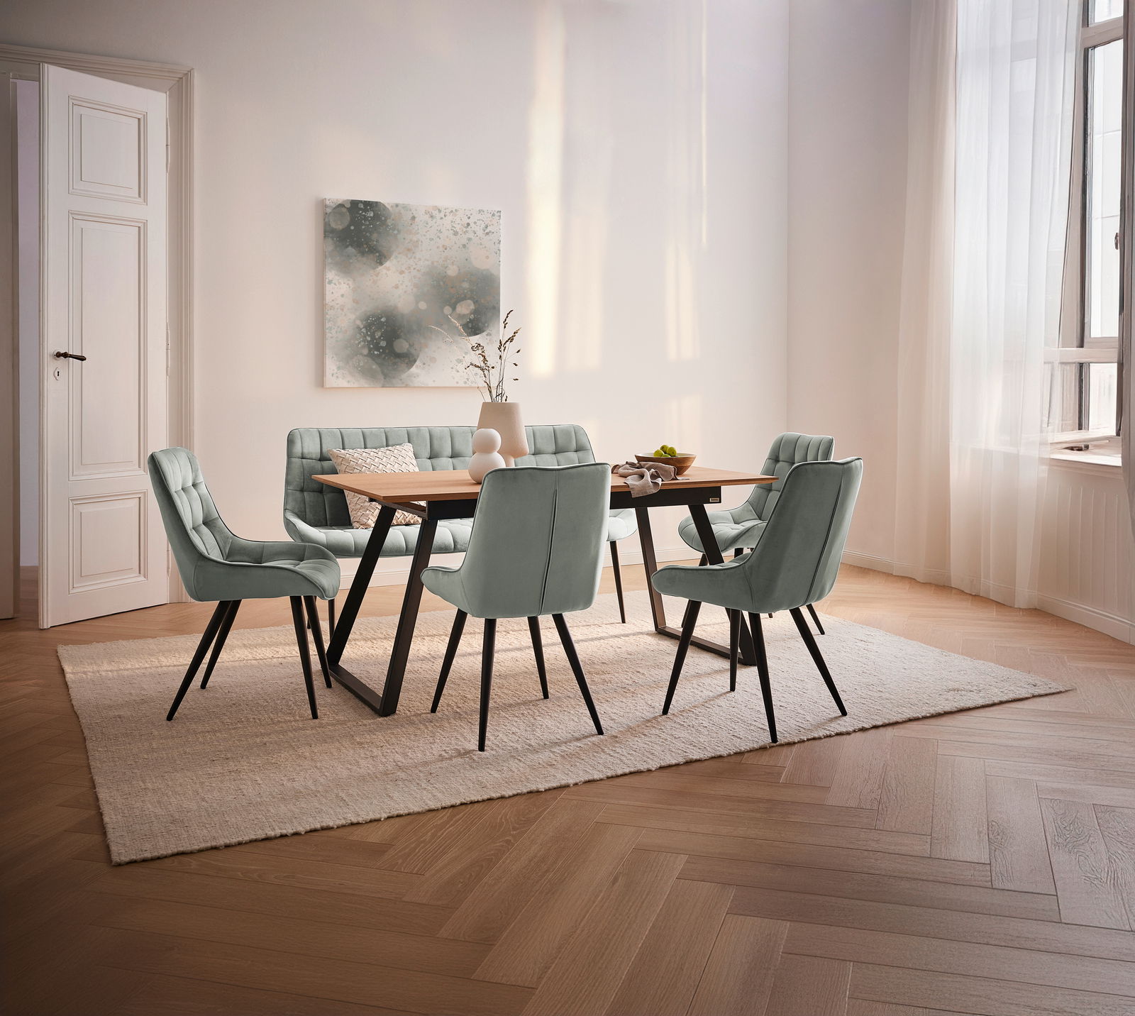 Esszimmer mit modernem Tisch und sechs gepolsterten Stühlen in einem hellen Raum mit großen Fenstern, seitliche Perspektive.