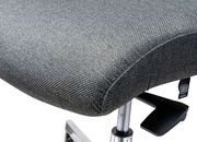 Nahaufnahme eines grauen Drehstuhlsitzes mit Stoffbezug und verstellbarem Hebel, seitliche Perspektive