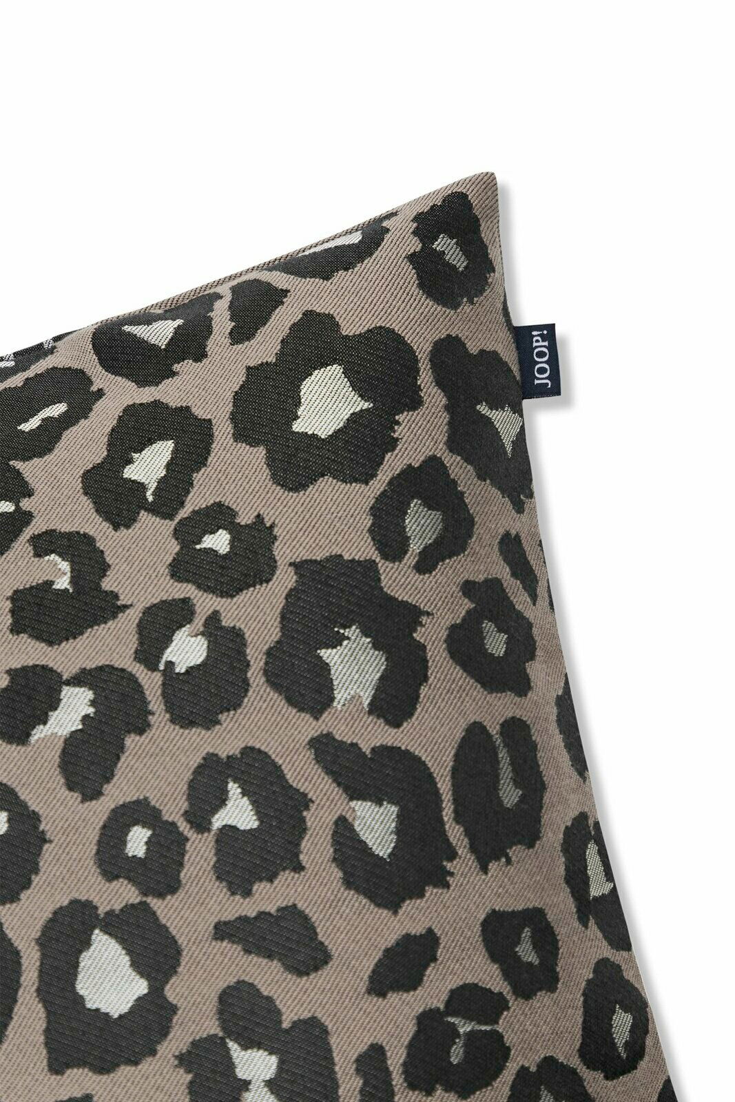 Zierkissenhülle mit Leopardenmuster in Nahaufnahme, perspektivisch von der Ecke fotografiert.