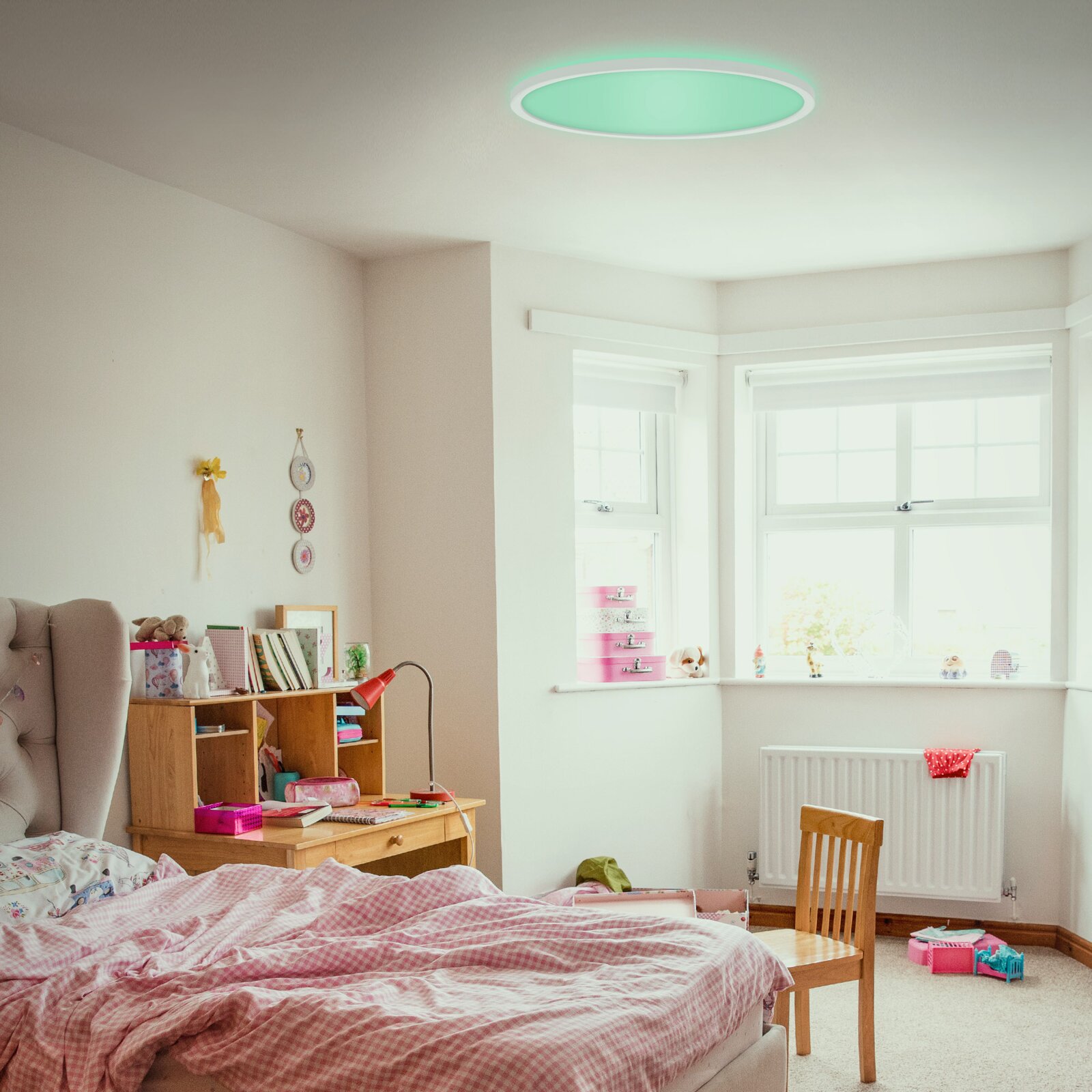 LED-Deckenleuchte in einem gemütlichen Schlafzimmer, von unten betrachtet, mit grünlichem Lichtschein.