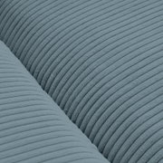 Close-up van een blauwe, geribbelde stof van een grote bank, gezien van bovenaf.