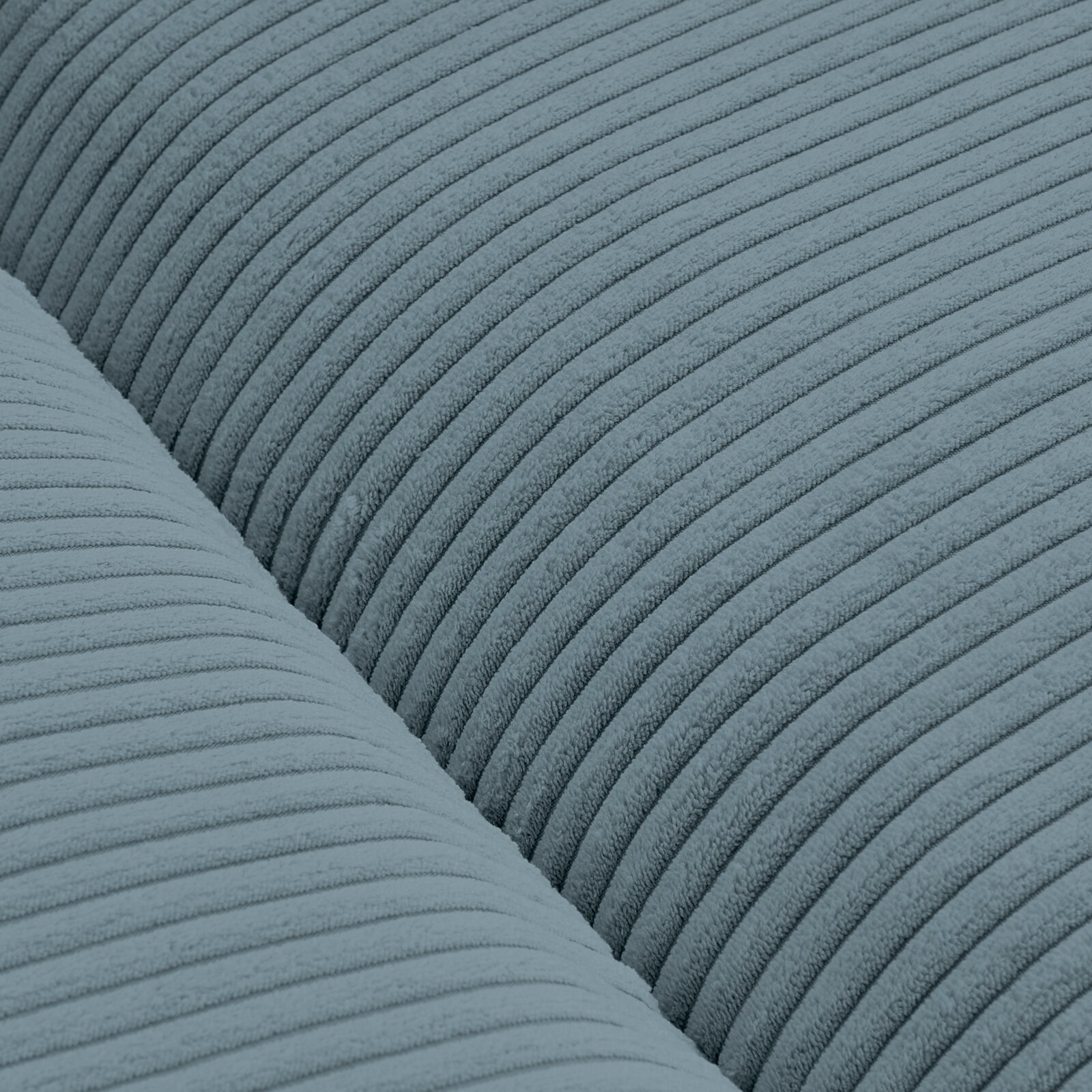 Close-up van een blauwe, geribbelde stof van een grote bank, gezien van bovenaf.
